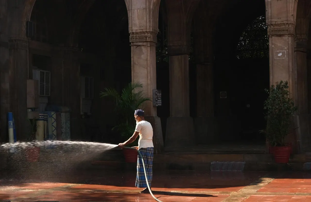 Regando o jardim em frente à mesquita